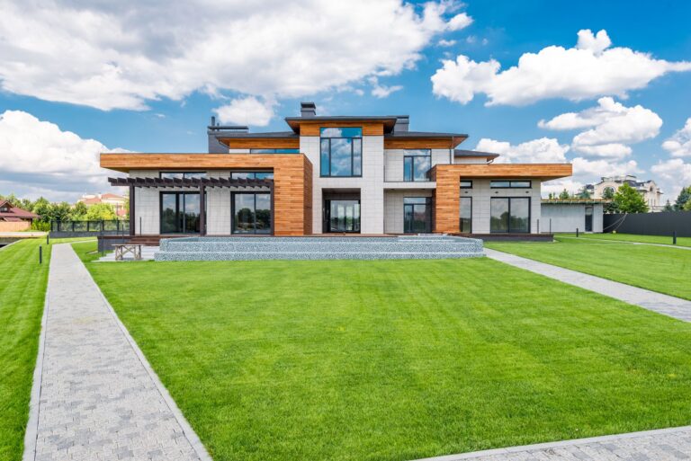 Neu gebautes Einfamilienhaus mit Baustellenzaun an einem hellen Tag