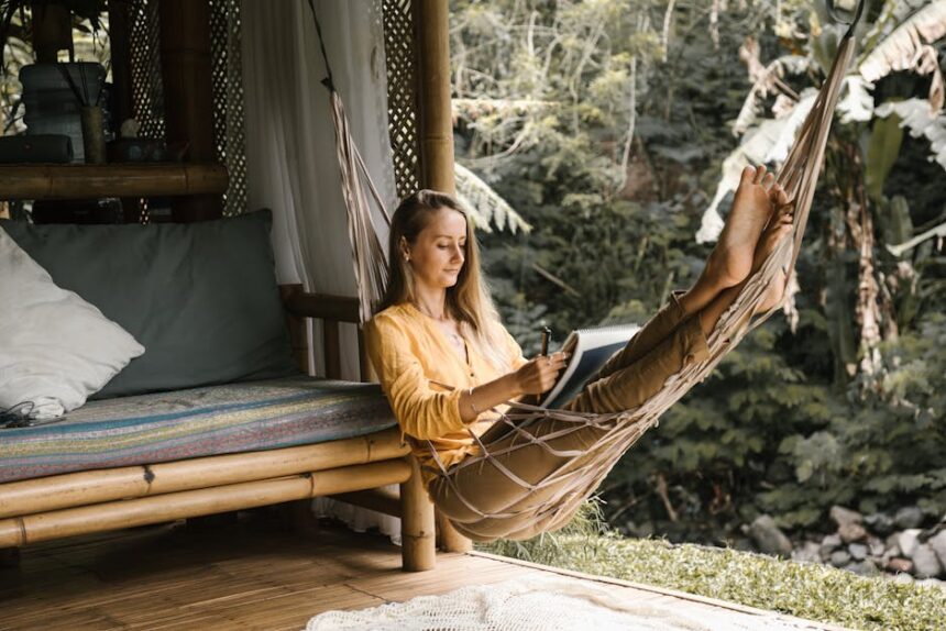 lento - Serene scene of a woman sketching in a hammock surrounded by lush greenery.